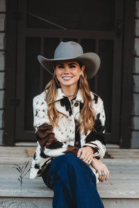 Woman in a cowboy hat sitting on steps outdoors