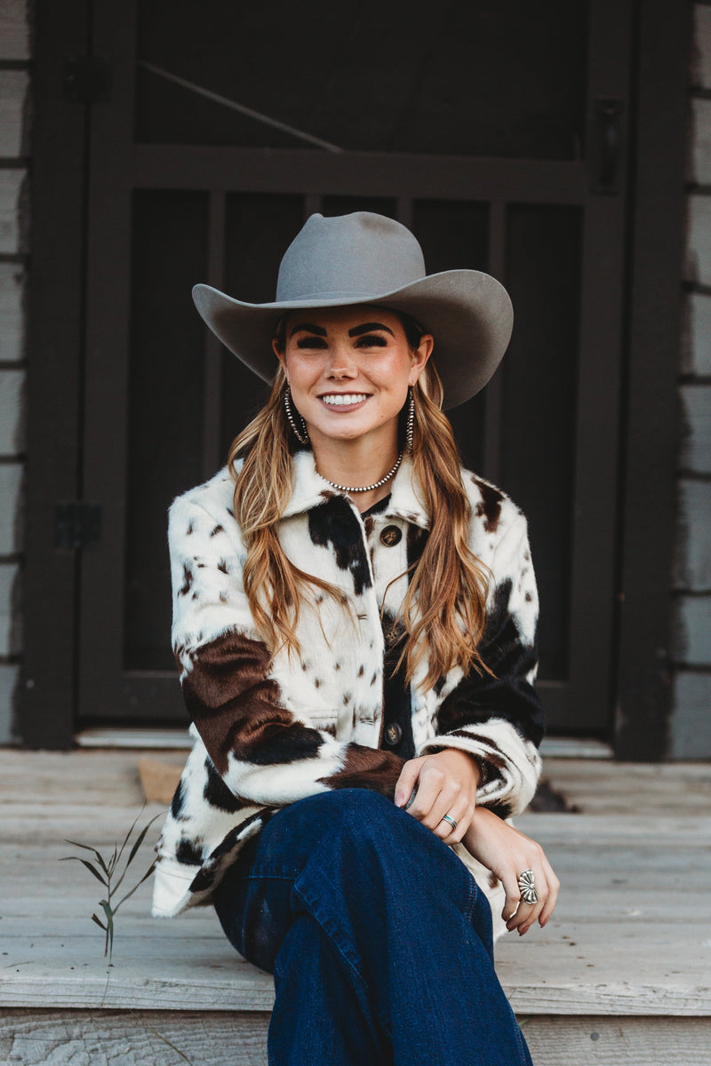 Woman in a cowboy hat sitting on steps outdoors